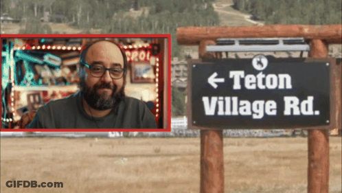 Man In Front Of Teton Village Road Sign GIF
