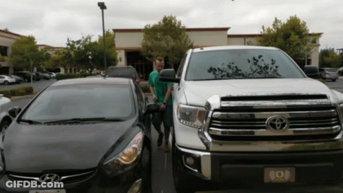 Man In Front Of Toyota Truck And Hyundai Car GIF