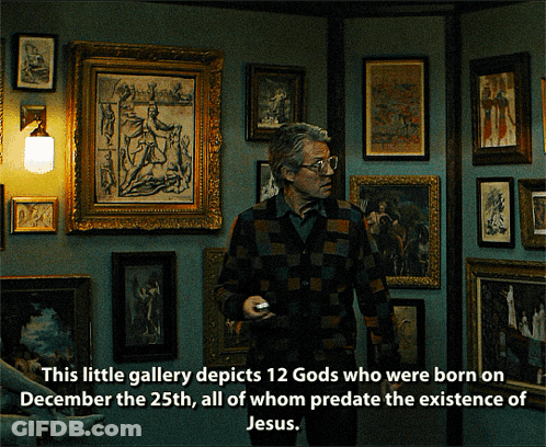 Man In Front Of Wall Of Framed Pictures This Little Gallery Depicts 12 Gods Born On December GIF