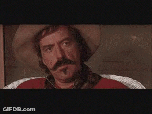 Man In Front Of Wall Of Pictures GIF