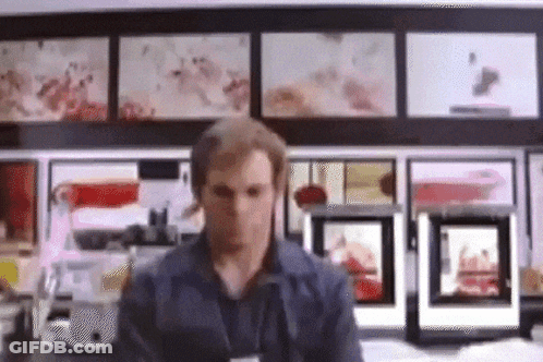 Man In Front Of Wall With Pictures GIF
