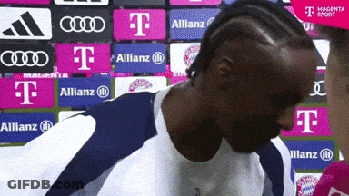 Man In Front Of Wall With T-Mobile Allianz Audi Logos GIF