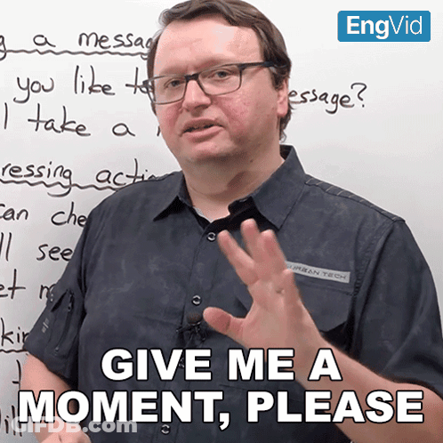 Man In Front Of White Board Saying Give Me A Moment Please GIF