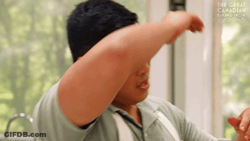 Man In Front Of Window With Arm Outstretched And The Great Canadian Baking Show Sign GIF
