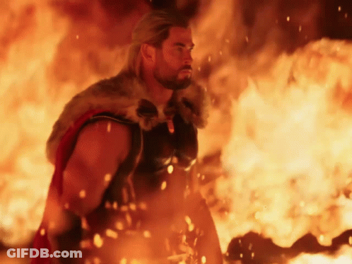 Man In Fur Cape Standing In Front Of Fire GIF