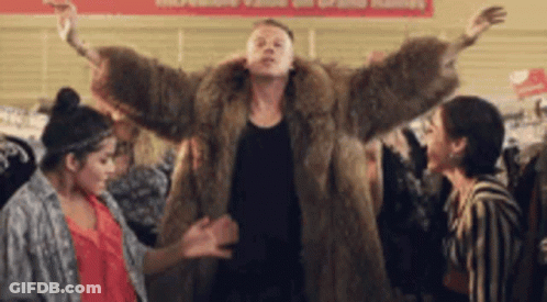 Man In Fur Coat Dancing With Two Women In Store GIF