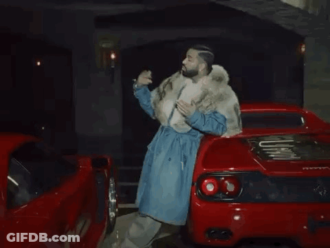 Man In Fur Coat Next To Red Sports Car GIF