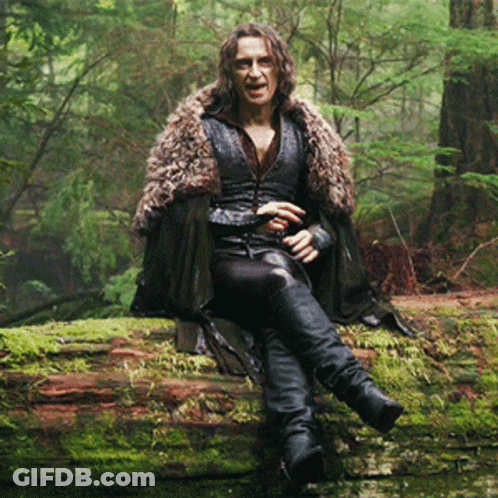 Man In Fur Coat Sitting On Log GIF