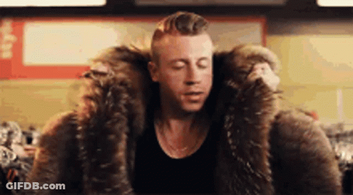 Man In Fur Coat Sitting With Eyes Closed GIF