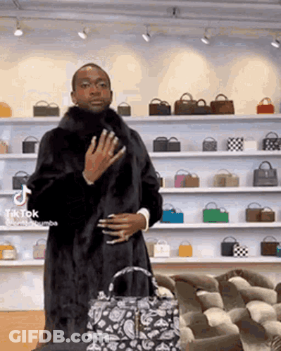 Man In Fur Coat Standing In Front Of Handbags GIF