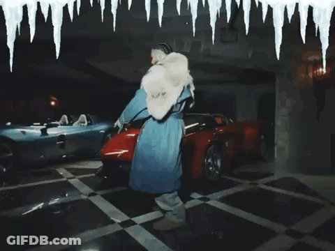 Man In Fur Coat Standing Next To Red Car GIF