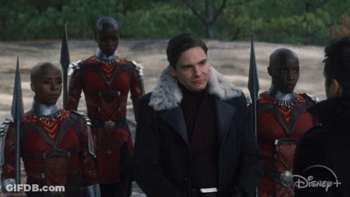 Man In Fur Coat Stands Before Crowd With Disney+ GIF