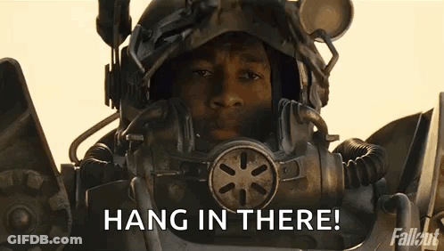 Man In Futuristic Helmet Holding Gun Saying Hang In There GIF