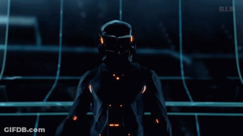 Man In Futuristic Suit Standing In Dark Room With Mem GIF