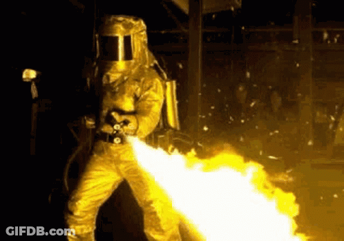 Man In Gas Mask Holding Flamethrower GIF