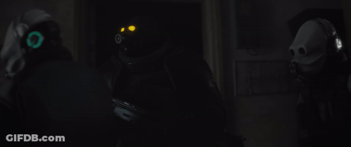 Man In Gas Mask Holding Gun In Dark Room GIF