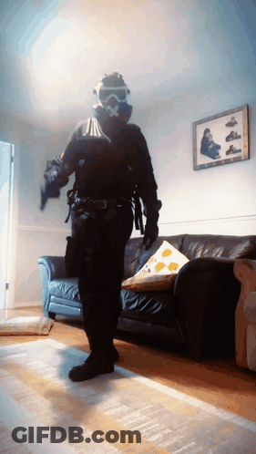 Man In Gas Mask In Living Room GIF
