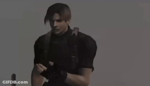 Man In Gas Mask Kneeling In Field Holding Camera GIF