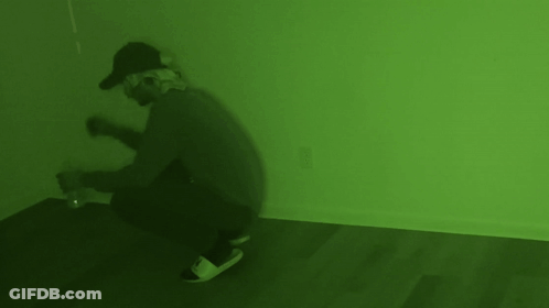 Man In Gas Mask Kneeling In Green Room GIF