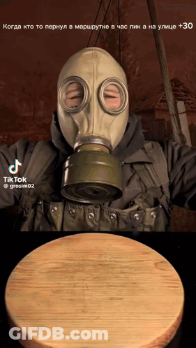 Man In Gas Mask Next To Cutting Board GIF