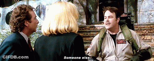 Man In Ghostbusters Jacket Talking To Woman And Man In Suit GIF
