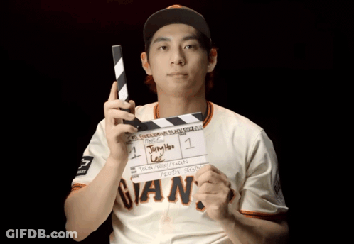 Man In Giants Jersey Holding Clapper Board GIF