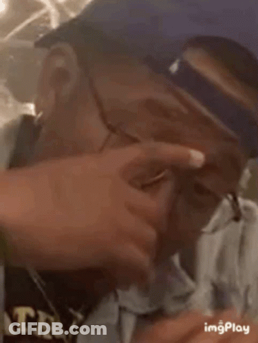 Man In Glasses And Baseball Cap Looking Down GIF