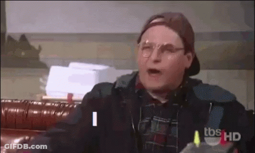 Man In Glasses And Baseball Cap Talking On Couch GIF