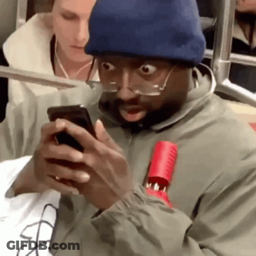 Man In Glasses And Beanie Looking At Phone GIF