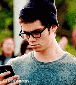 Man In Glasses And Beanie Looking At Phone GIF