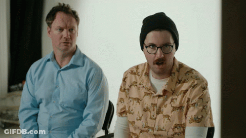 Man In Glasses And Beanie Next To Man In Leopard Print Shirt GIF
