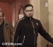 Man In Glasses And Black Jacket Standing GIF