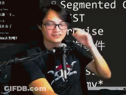 Man In Glasses And Black Shirt In Front Of Microphone With Segmented On Blackboard GIF