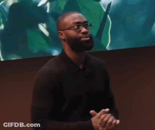 Man In Glasses And Black Shirt In Front Of Screen With Green Leaf GIF