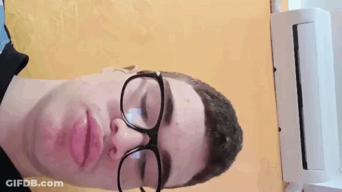 Man In Glasses And Black Shirt Laying Down GIF