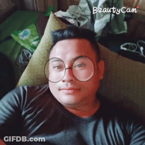 Man In Glasses And Black Shirt Laying On Couch With Beautycam Watermark GIF