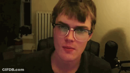 Man In Glasses And Black Shirt Looking At Camera GIF