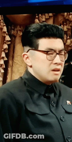 Man In Glasses And Black Shirt With Pin GIF
