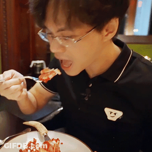 Man In Glasses And Black Smiley Shirt Eating Food GIF