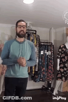 Man In Glasses And Blue Shirt At Clothes Display GIF