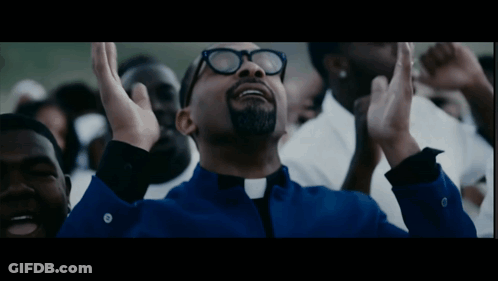 Man In Glasses And Blue Shirt Hands Up In Crowd GIF
