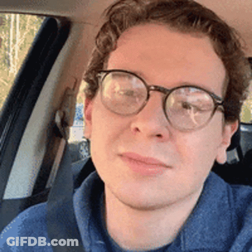 Man In Glasses And Blue Shirt Sitting In Car GIF