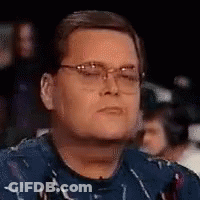 Man In Glasses And Blue Shirt Sitting In Crowd GIF