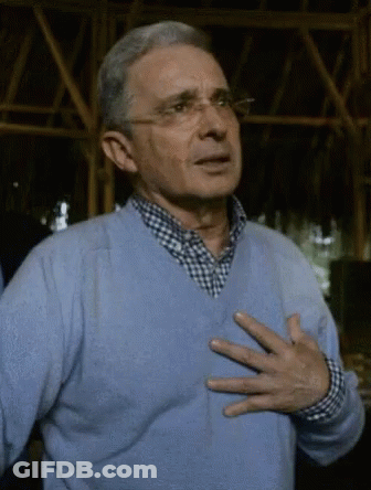 Man In Glasses And Blue Sweater Holding Chest GIF