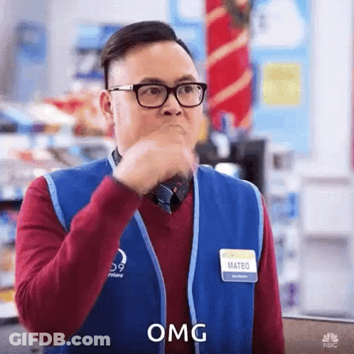 Man In Glasses And Blue Vest Covering Mouth Saying OMG GIF