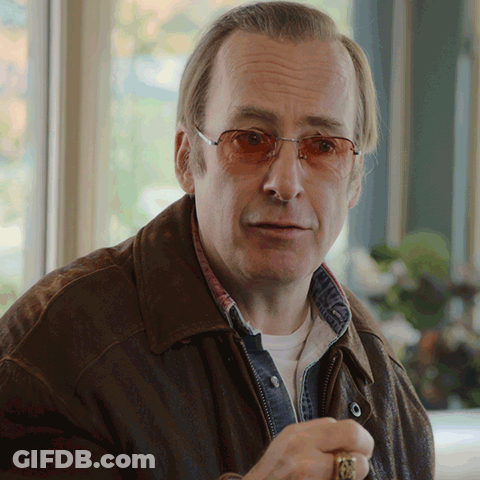 Man In Glasses And Brown Jacket Looking At Camera GIF