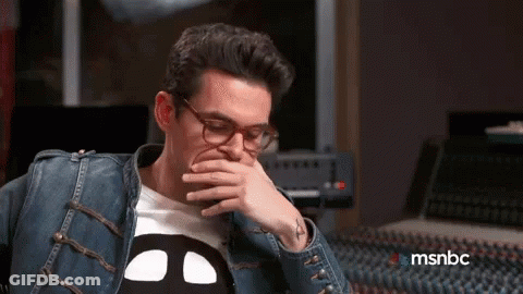 Man In Glasses And Denim Jacket Covering Mouth GIF