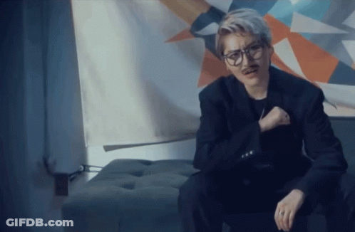 Man In Glasses And Fake Mustache Sitting On Ottoman GIF