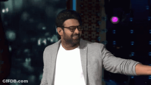 Man In Glasses And Gray Jacket In Front Of Purple Light GIF
