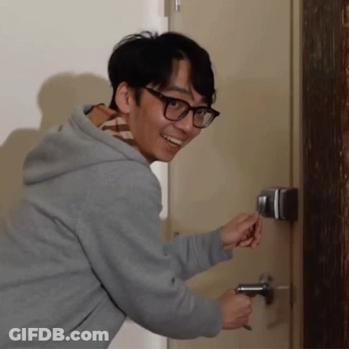Man In Glasses And Grey Hoodie Opening Door With Key GIF